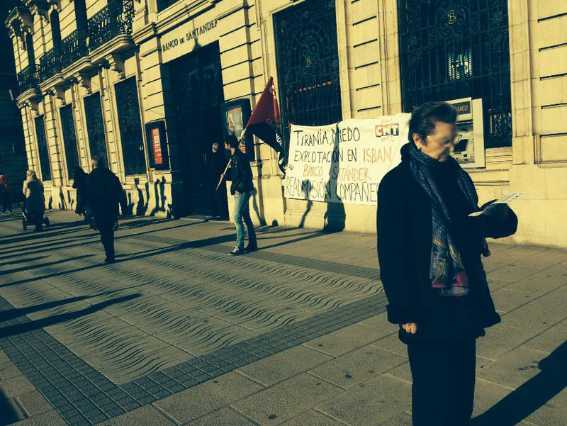 PAreante lee la octavilla en el Paseo Pereda, frente a la oficina central del banco